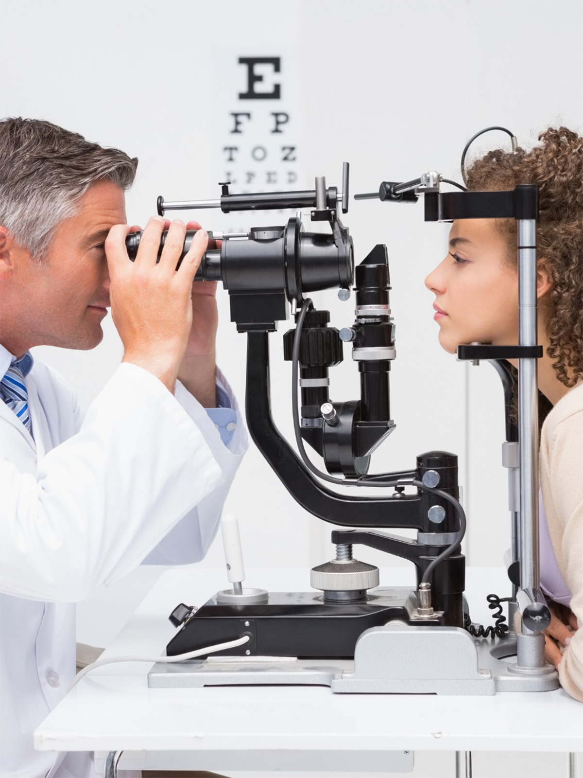 Ophthalmologist checking female patients retinas